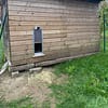 Chalet en bois utilisé comme poulailler avec une porte automatique terceira solaire.